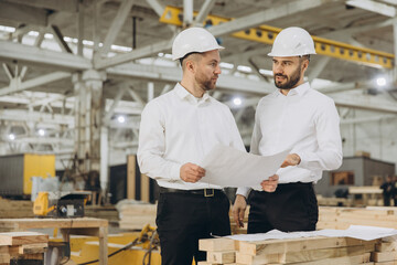 Engineers examining blueprint in modular building factory