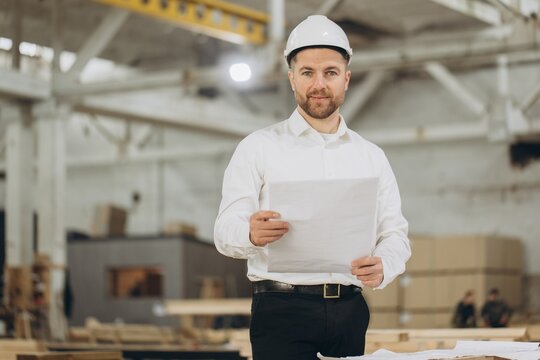 Engineer holding blueprint in modular building factory