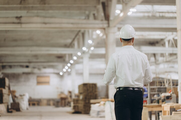 Fototapeta premium Engineer walking in modular building factory inspecting construction materials