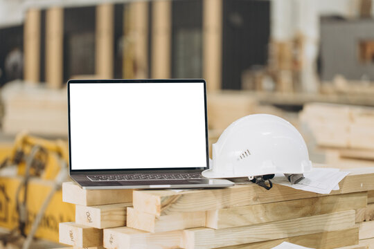 Laptop showing mockup screen with white hard hat in modular building industry