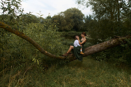 Mother with her child sitting on a tree branch