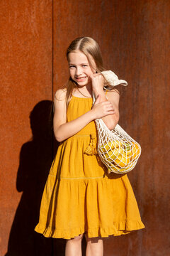 Cute girl with shopping bag looking into camera