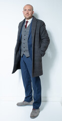 A modern corporate man in a tailored blue three piece suit. Grey tweed knit business suit for lawyers, bankers and for men with high power positions. Corporate barrister and peaky blinders cos play.
