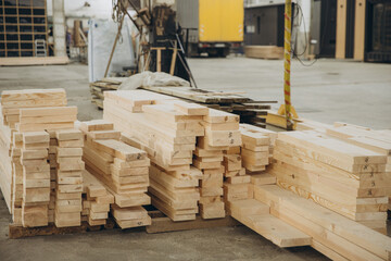 Stacks of lumber sit in a warehouse awaiting use in modular building industry