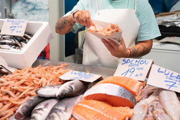 Anonymous fish market vendor behind the showcase