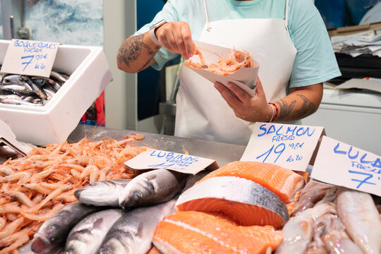 Anonymous fish market vendor behind the showcase