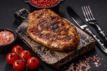Juicy pork steak baked on the grill with salt, spices and herbs