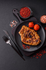 Juicy pork steak baked on the grill with salt, spices and herbs