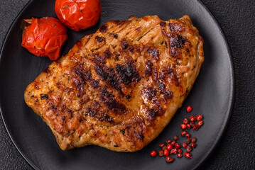 Juicy pork steak baked on the grill with salt, spices and herbs