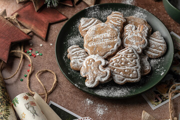 Christmas gingerbread cookies homemade in plate on rustic table with fir branches, spices, christmas decorations. Merry Christmas, atmospheric holiday