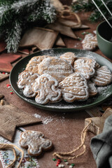 Christmas gingerbread cookies homemade in plate on rustic table with fir branches, spices, christmas decorations. Merry Christmas, atmospheric holiday