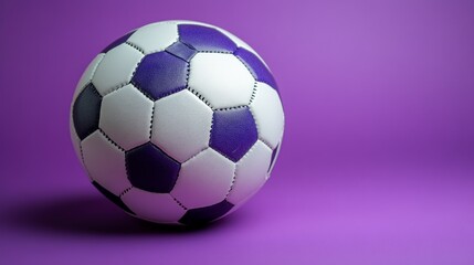 Obraz premium Close-up of a white and purple soccer ball on a purple background.
