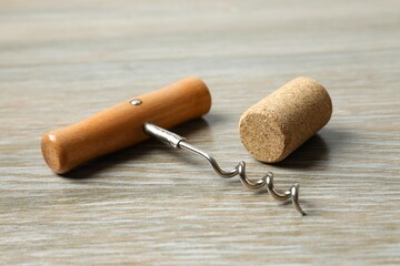Wine corks with corkscrew on wooden background 