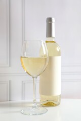Bottle of white wine and glass on table