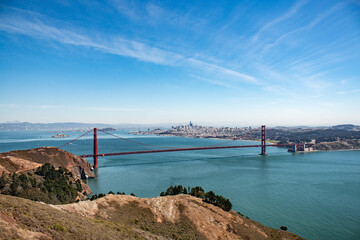 Golden Gate Bridge spanning San Francisco Bay, with the city skyline in the background under a clear blue sky.
