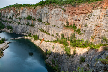 Expansive Rock Quarry Featuring Steep Cliffs and a Tranquil Water Body

