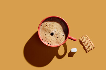 Top view of cup of coffee on orange background