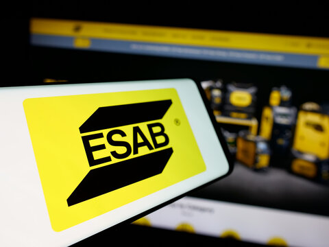 Stuttgart, Germany - 11-07-2024: Mobile phone with logo of industrial company ESAB Corporation on screen in front of business website. Focus on center-left of phone display.