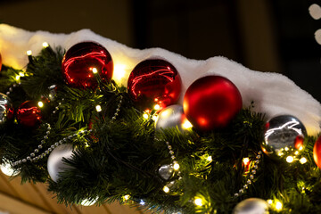 Christmas border made of fir branches on a white background with decorations of red and white balls. Postcard