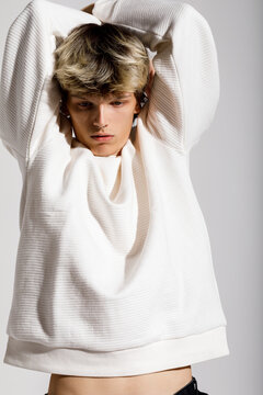 Young model poses in a trendy white sweater 