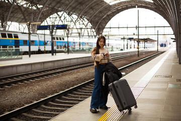 Woman in Warm Clothing Waiting at Train Station