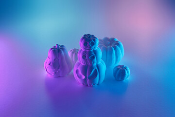 White Halloween pumpkin sculptures in neon light