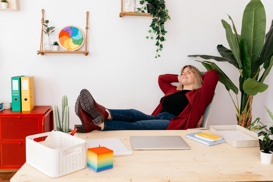 Positive manager relaxing on chair during break at work