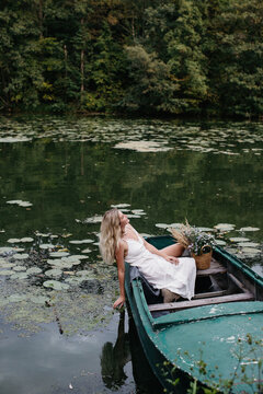 Young woman relaxing in rowboat on lake
