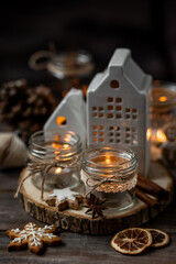 Creating holiday mood, festive atmosphere at home. Christmas spirit, atmospheric composition with handmade aroma candles made from simple glass jars, homemade gingerbread cookies, anise cinnamon scent