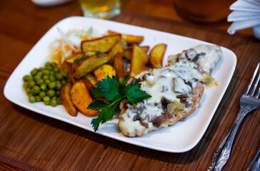Fried meat with mushrooms and baked potatoes. Russian cuisine
