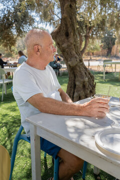 Senior Man Relaxing With Ice Coffee At Farmers Market
