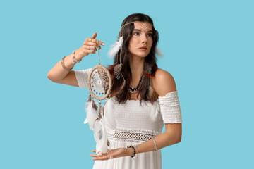 Beautiful female shaman with dream catcher on blue background