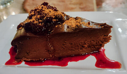 Succulent double chocolate cheesecake dessert with raspberry sauce and cocoa topping
