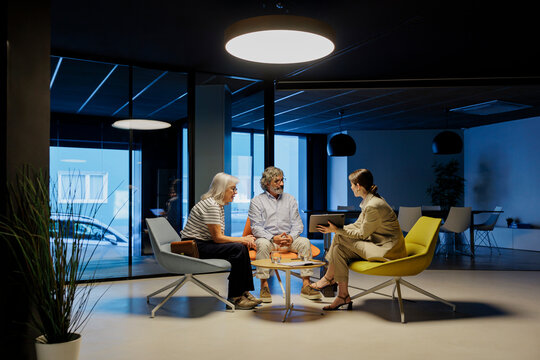 Financial advisor showing pension plan to senior couple in office