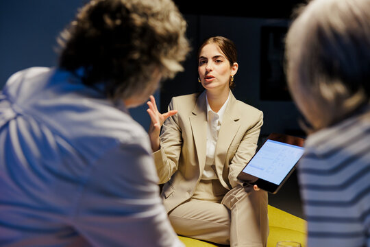 Financial advisor showing documents on tablet to senior clients