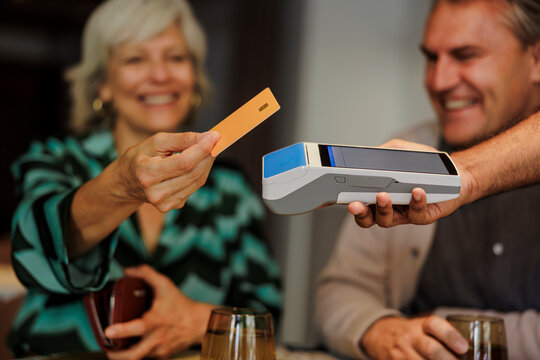 Woman using credit card making payment through pos terminal