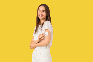 Young woman with applied contraceptive patch on yellow background