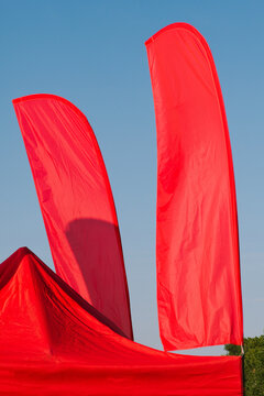 Red flags and a red tent against a blue sky