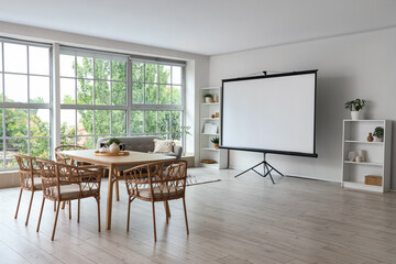 Interior of light room with projector screen and dining table