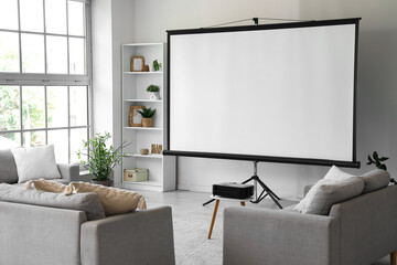 Interior of light room with projector screen, shelf unit and sofas