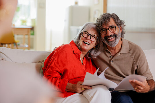 Happy senior couple reviewing finances with financial advisor at home
