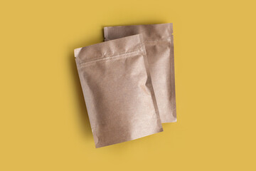 Kraft paper empty bags isolated in brown card box mock up on yellow background. Eco friendly pack...