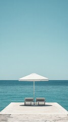 Fototapeta premium Serene Seascape: Two Lounge Chairs Under a White Parasol on a Calm Ocean Pier
