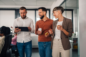 Business people walking and talking in office corridor