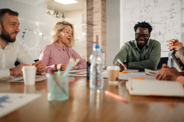 Diverse business team collaborating on project in modern office meeting