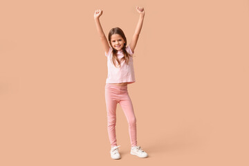 Portrait of happy little girl on beige background