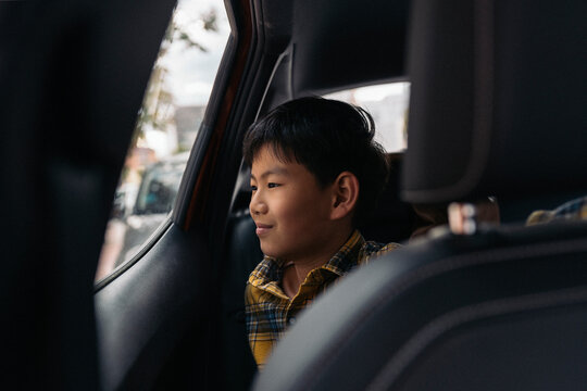 Child looking out of car window with a thoughtful expression