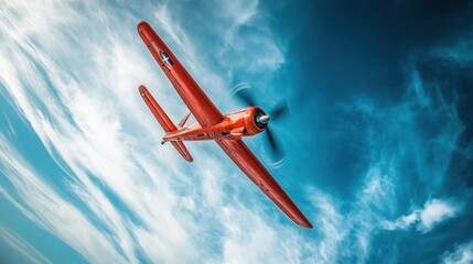 A vibrant red aircraft flying against a dramatic sky, showcasing aviation and speed.