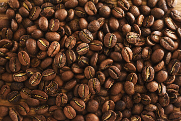 Naklejka premium Roasted brown coffee beans on rustic wooden background, selective focus