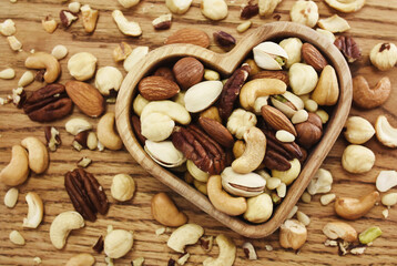 Colorful mix of various nuts: peanut and cashew, hazelnut and almond, pine nuts and walnut; healthy diet snack; vegan food background